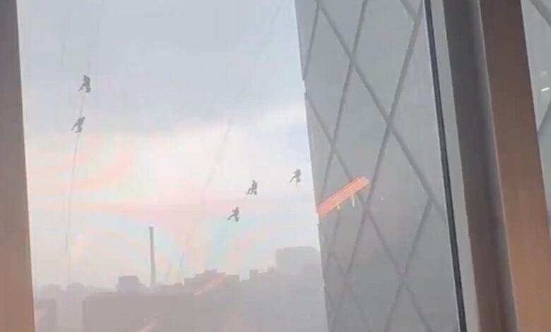 High winds leave crew dangling from Beijing skyscraper